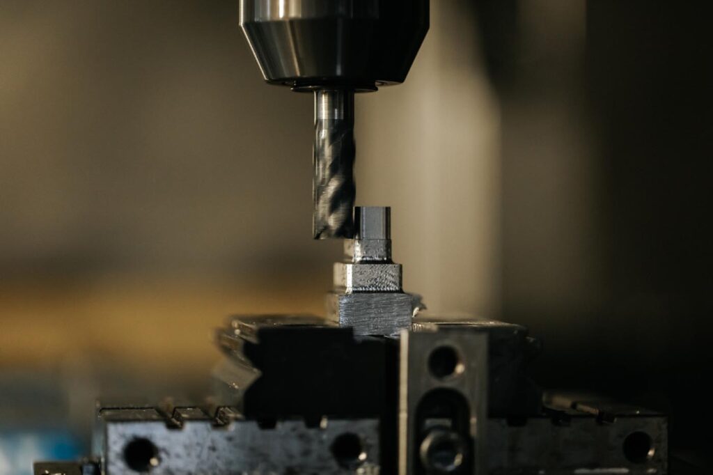 PHOTO D'UNE MACHINE ENTRAIN DE TRAVAILLER SUR UNE PETITE PIÈCE DE MOULE À INJECTION PLASTIQUE