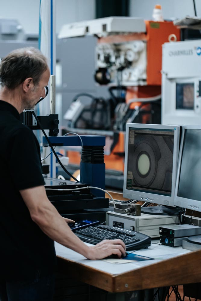PHOTO D'UN INDUSTRIEL DEVANT UN ÉCRAN DE CONTRÔLE DE MACHINE POUR MOULE À INJECTION PLASTIQUE