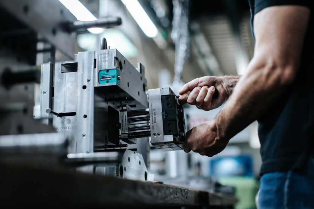 PHOTO D'UN INDUSTRIEL ENTRAIN DE TRAVAILLER SUR UN MLOULE À AMS SYSTEM